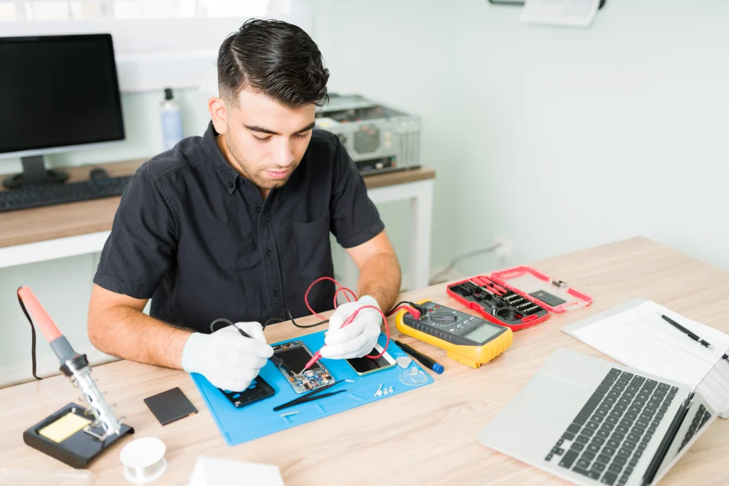 hispanic male engineer checking connections damaged smartphone with multimeter his repair shop 11zon